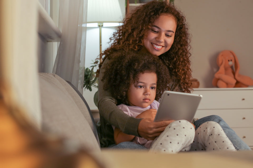 Mother and daughter reading on a tablet at home